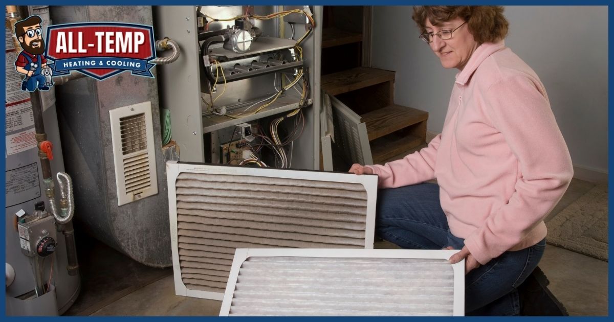 Homeowner replacing a dirty HVAC air filter during furnace maintenance.