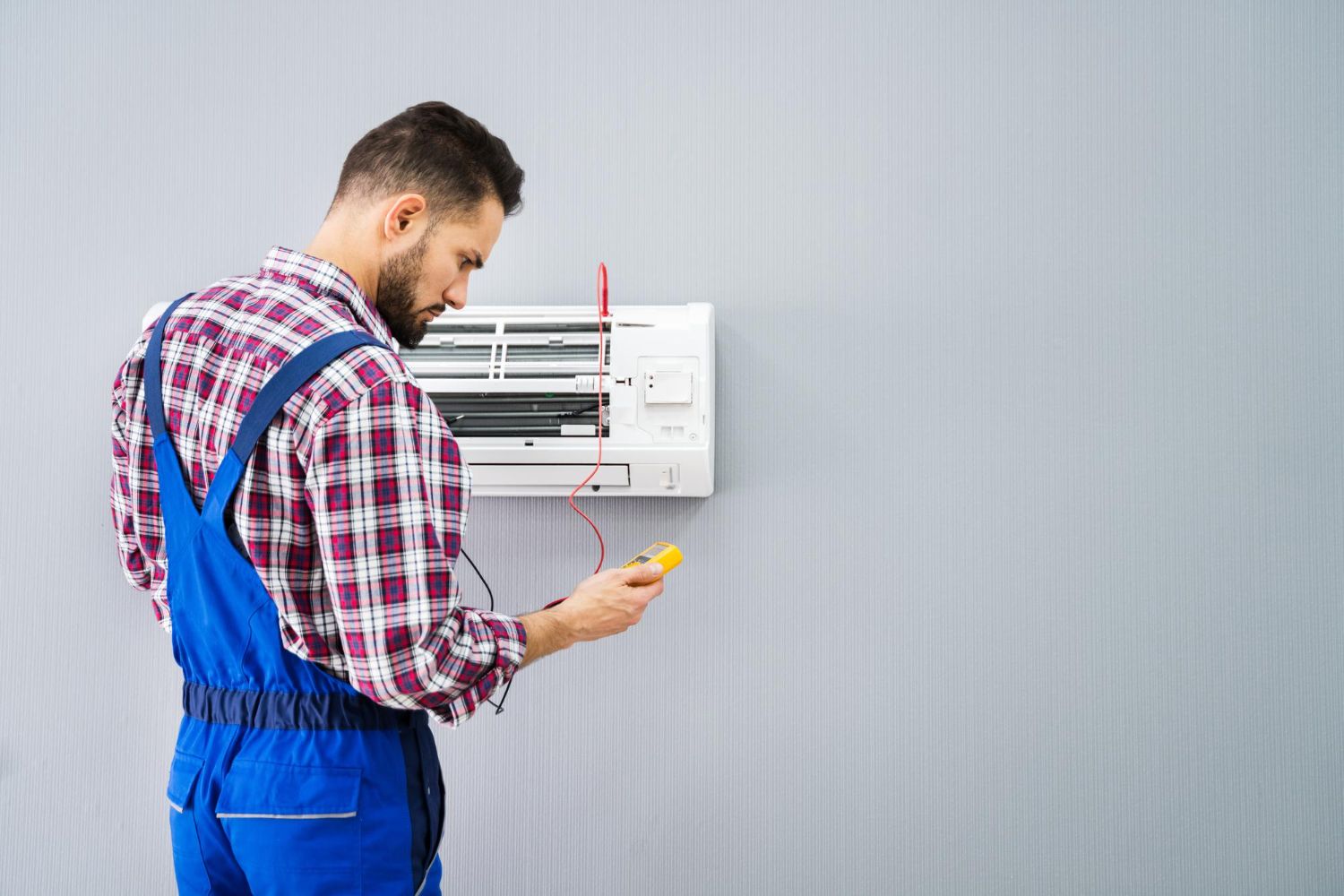 HVAC technician diagnosing a ductless mini split air conditioner