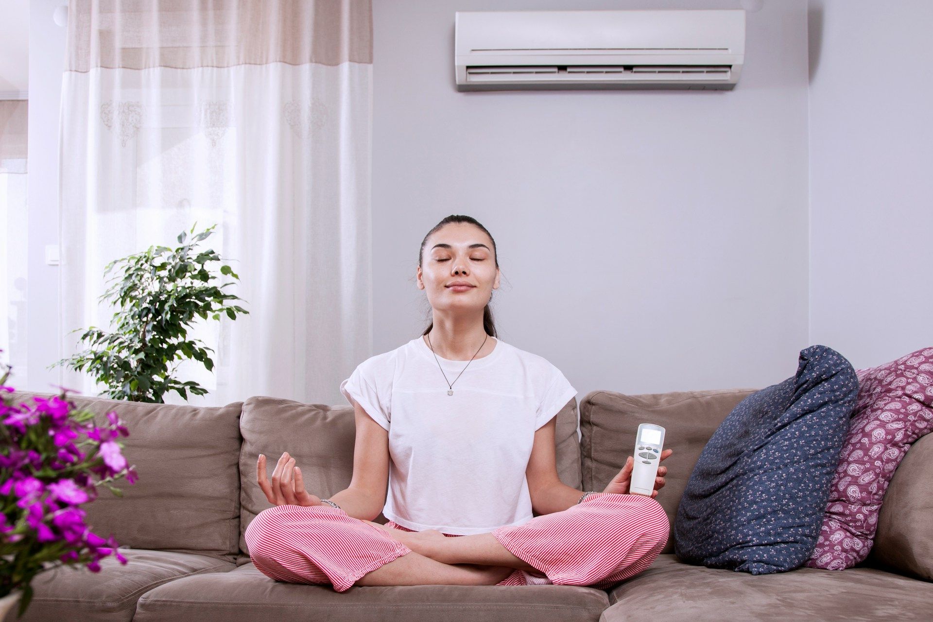 Woman meditating with AC remote