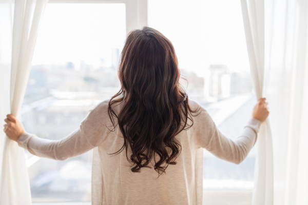 Woman looking outside through window