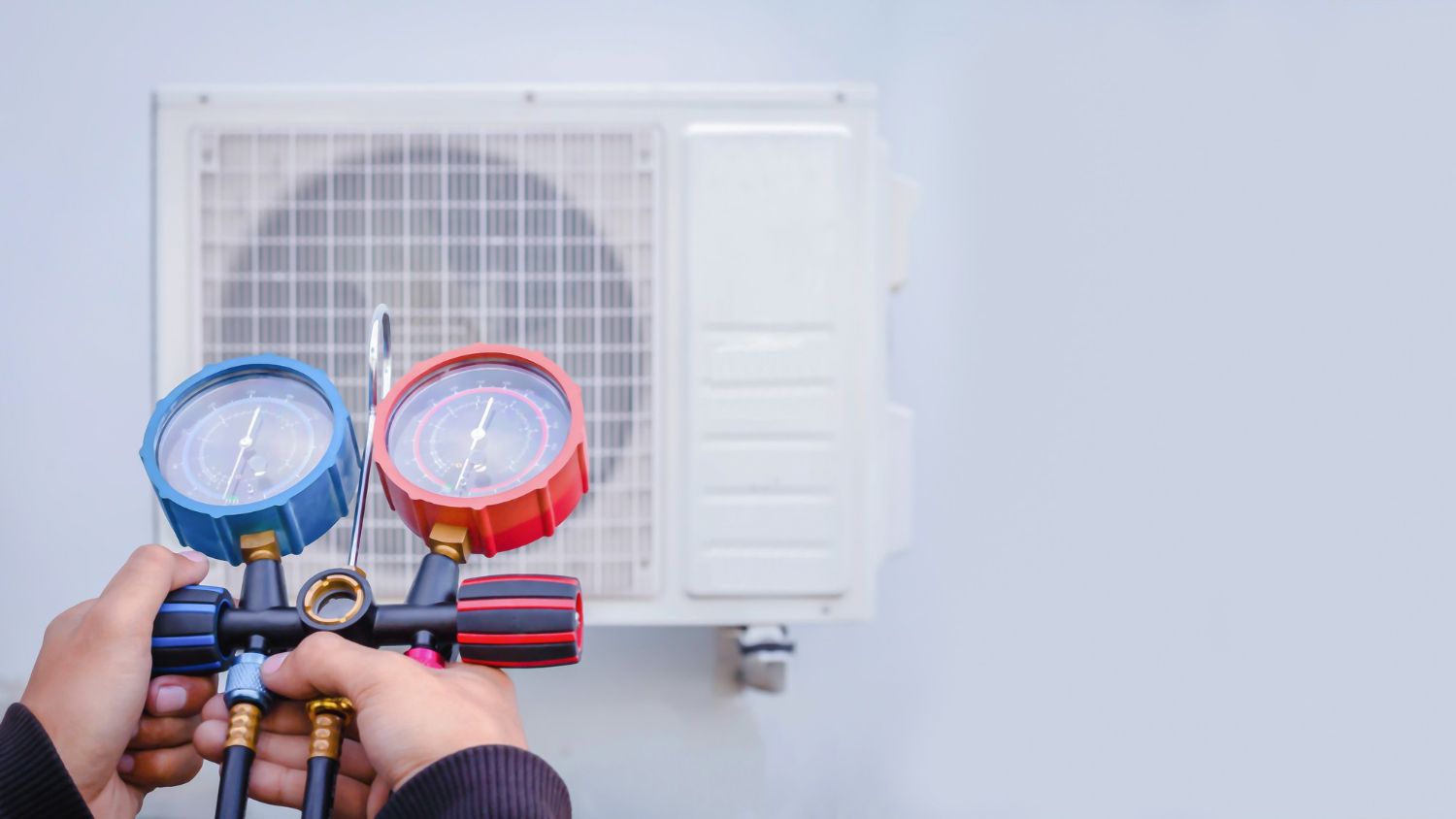 HVAC technician checking refrigerant pressure on a mini split system